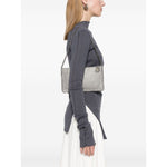 Woman wearing Stella McCartney Falabella Clutch Shoulder Bag in light grey faux suede with chain-link strap and whipstitch trim.