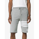 Model wearing Thom Browne Shorts Light Grey with 4-Bar stripe, elastic waistband, and grosgrain ribbon trim, front view.