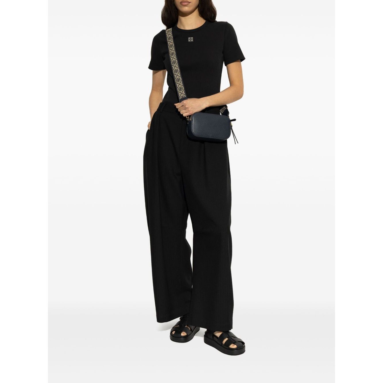 Model wearing Tory Burch Sandals Black with multiple strap design, logo detailing, cushioned sole and open toe, styled with black outfit.