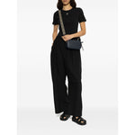 Model wearing Tory Burch Sandals Black with multiple strap design, logo detailing, cushioned sole and open toe, styled with black outfit.