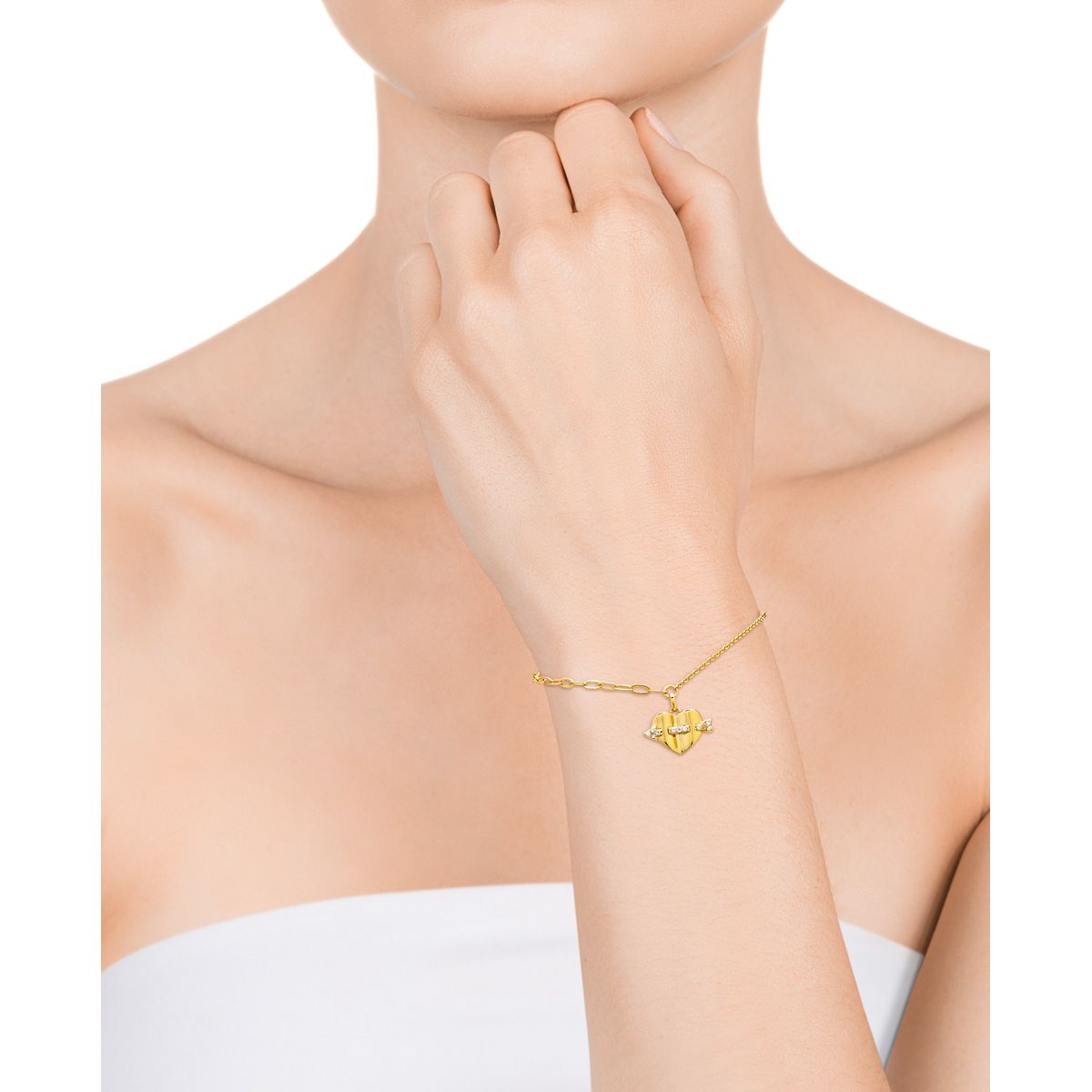 Close-up of woman wearing a delicate gold bracelet on her wrist against a white background.
