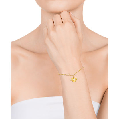 Close-up of woman wearing a delicate gold bracelet on her wrist against a white background.