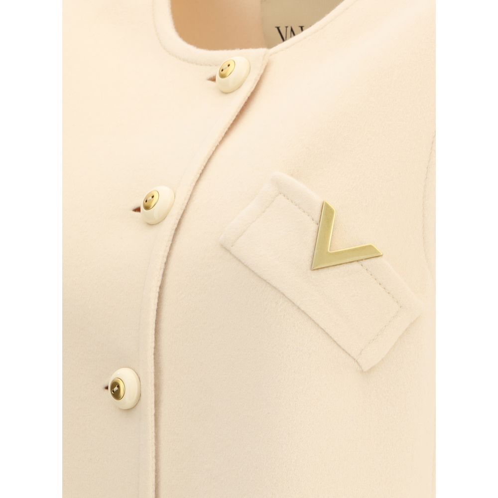 Close-up of Valentino Cream Fleece Wool Clothing vest with button closure, gold V logo, and welt pockets for elegance and warmth.