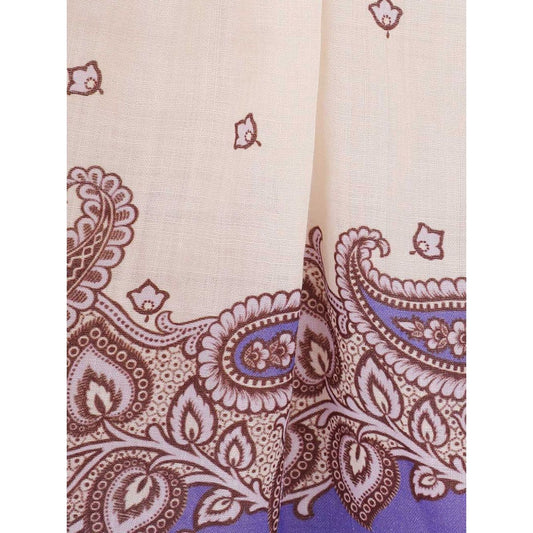 Close-up of paisley pattern on fabric in ecru and purple hues, showcasing intricate design details.